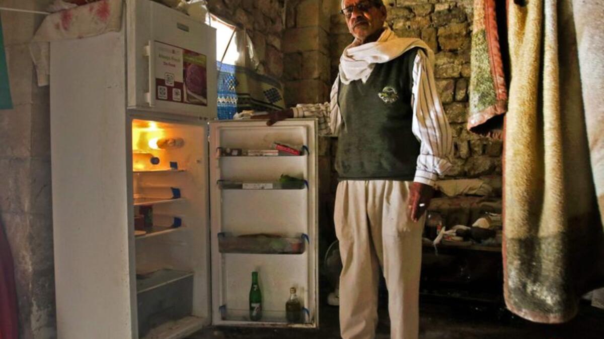 A Lebanese man displays the content of his refrigerator at his apartment in the southern city of Sidon. Image Credit: AFP