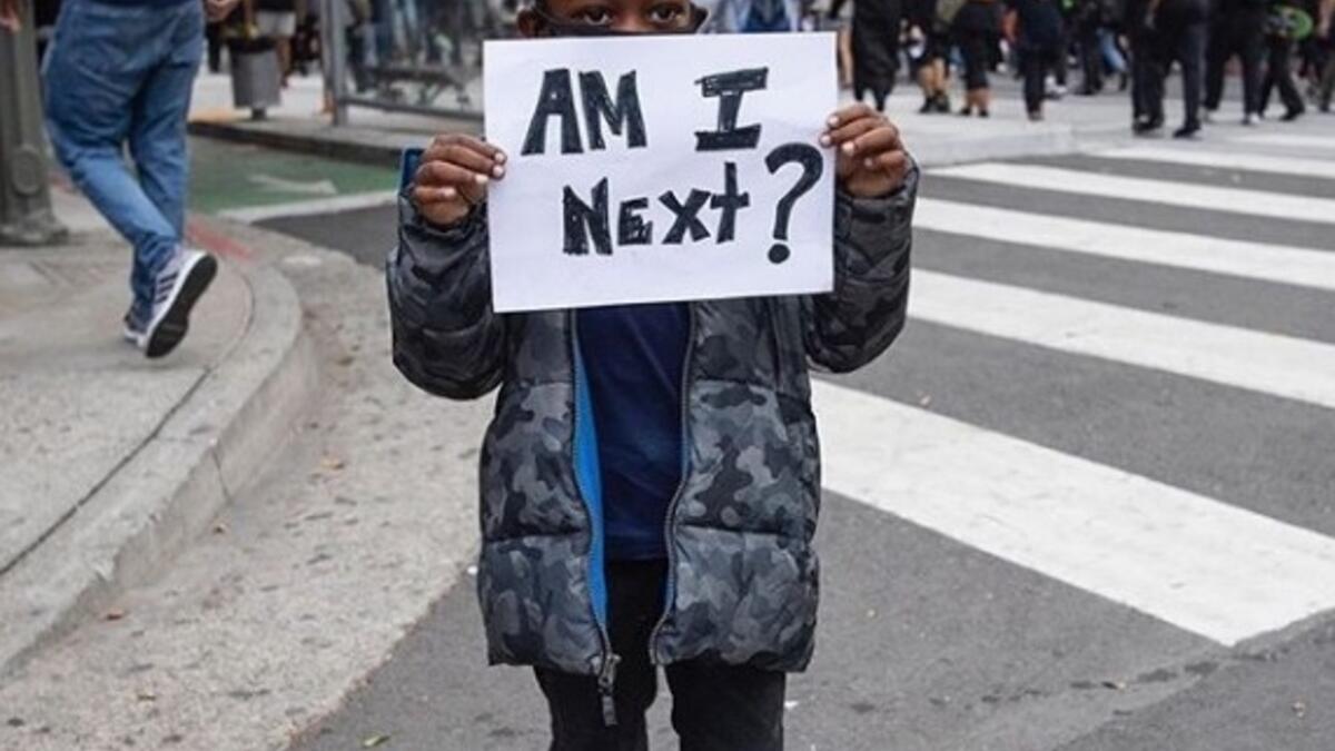 A boy holds a sign during a protest Friday in downtown Los Angeles over the death of George Floyd (unicefus/Instagram)