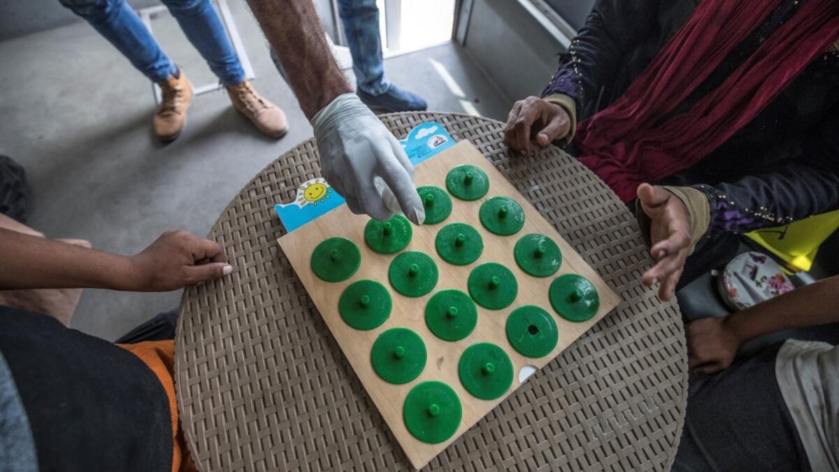 Homeless children play an educational game with a social worker inside one of the mobile units run by the Egyptian authorities and used as part of the "Atfal bala ma'wa" (Children without a home) social program, in the capital Cairo's Abbasia district on June 22, 2020. Khaled DESOUKI / AFP