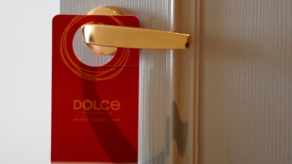 A placard hangs on a room's doorknob at the newly-inaugurated Dolce Hanoi Golden Lake hotel, the world's first gold-plated hotel, in Hanoi on July 2, 2020. Manan VATSYAYANA / AFP