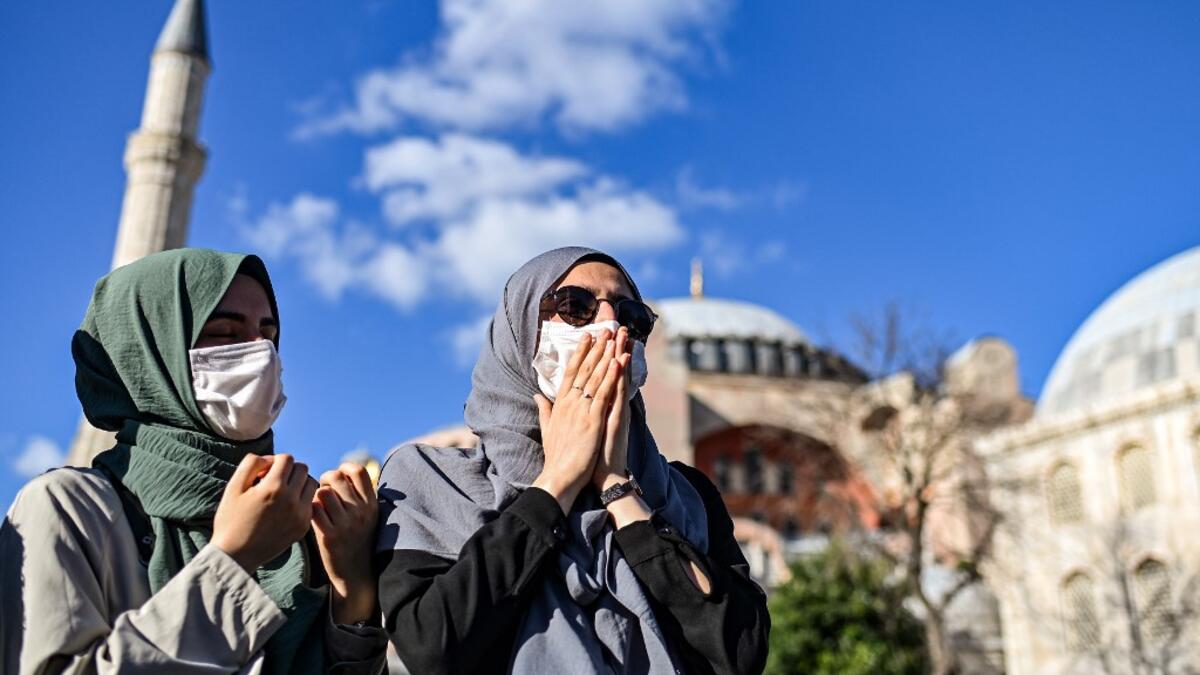 Women pray outside the Hagia Sophia museum on July 10, 2020 in Istanbul as people gather to celebrate after a top Turkish court revoked the sixth-century Hagia Sophia's status as a museum, clearing the way for it to be turned back into a mosque. The Council of State, the country's highest administrative court which on July 2 debated a case brought by a Turkish NGO, cancelled a 1934 cabinet decision and ruled the UNESCO World Heritage site would be reopened to Muslim worshipping. The sixth-century Istanbul b
