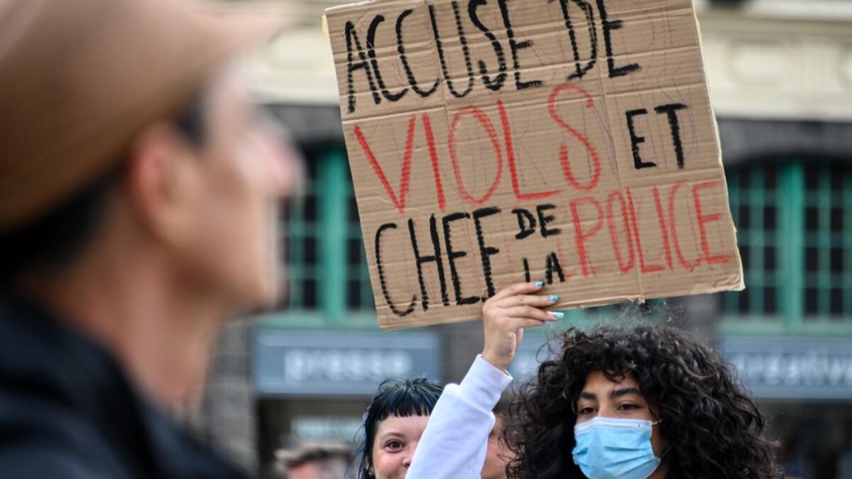 A protester holds a placard reading 'accused of rape and police chief' during a demonstration called by feminist movements on the main square of Lille, on July 10, 2020, to denounce the nomination of French Interior Minister, facing rape accusations and French Justice Minister who criticised the #MeToo movement against sexual harassment. DENIS CHARLET / AFP
