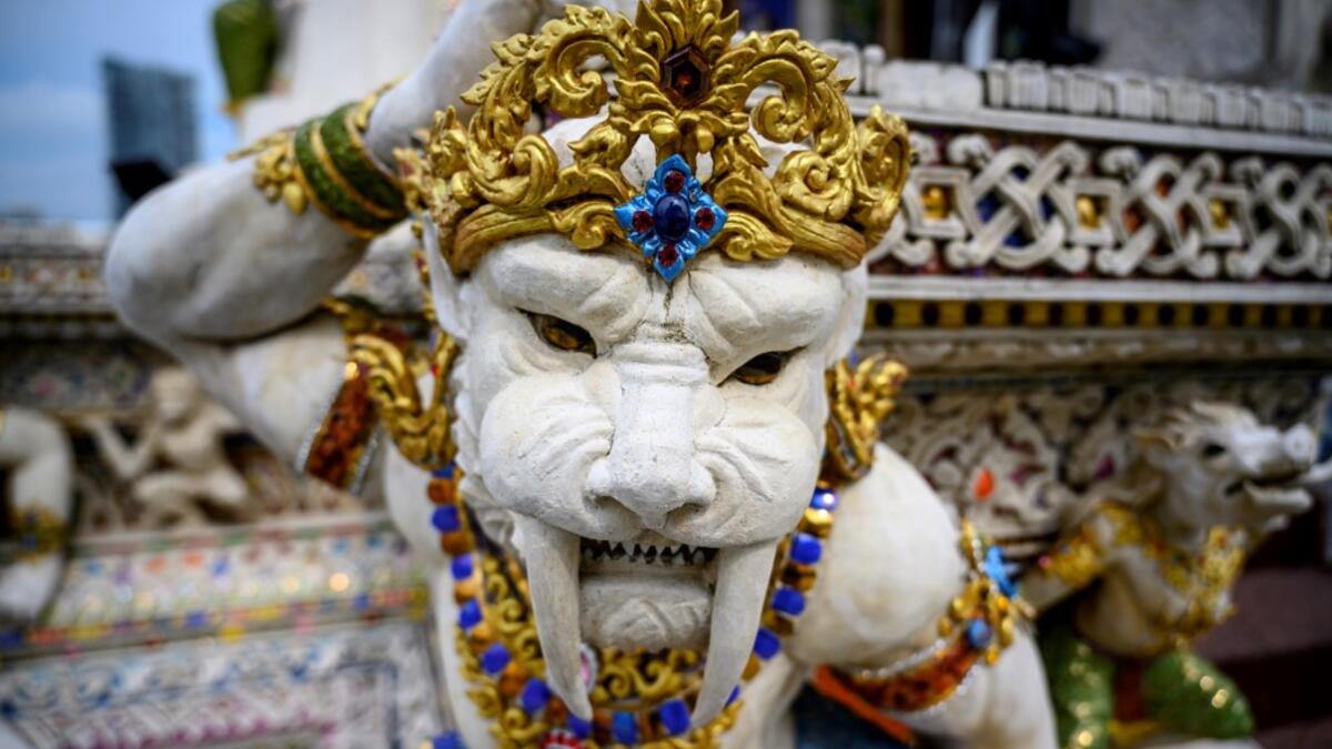 This photograph taken on July 14, 2020 shows a statue of an imaginary creature outside the Wat Pariwat Buddhist temple in Bangkok. Wat Pariwat, also known as "the David Beckham Temple", is decorated with statues of superheroes and comic characters as well as mythical and imaginary creatures. A golden-plated sculpture of the English football player holding the base of a Buddha statue in one of the buildings gives the temple its nickname. Mladen ANTONOV / AFP