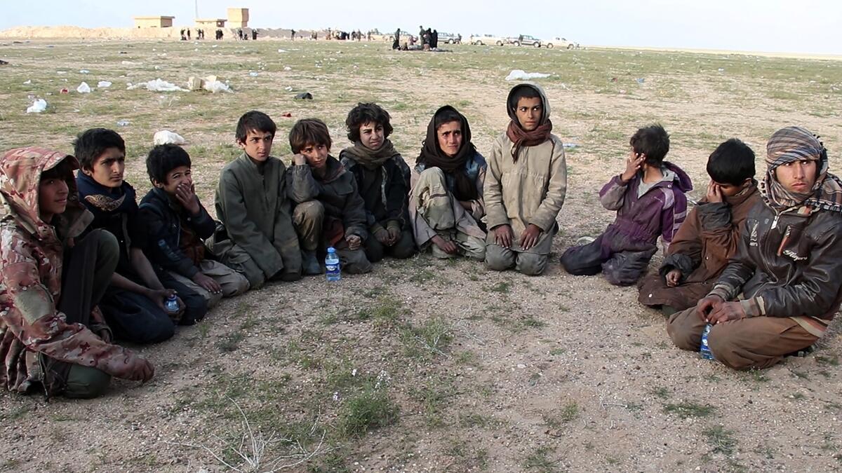 Saddam, (R) a 15 year old Yazidi boy and ten other Yazidi children gather in a area held by the US-backed Kurdish-led Syrian Democratic Forces (SDF), in the eastern Syrian province of Deir Ezzor, after fleeing the Islamic State (IS) group's embattled holdout of Baghouz, on February 23, 2019. The eleven Yazidi children were rescued by US-backed forces from IS's last sliver of territory in the village of Baghouz near the Iraqi border. (AFP / -)