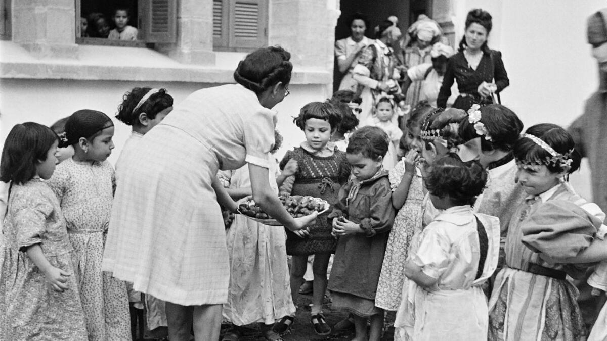 A teacher gives cakes to schoolgirls, in October 1945, in a school in Rabat, Morocco. AFP