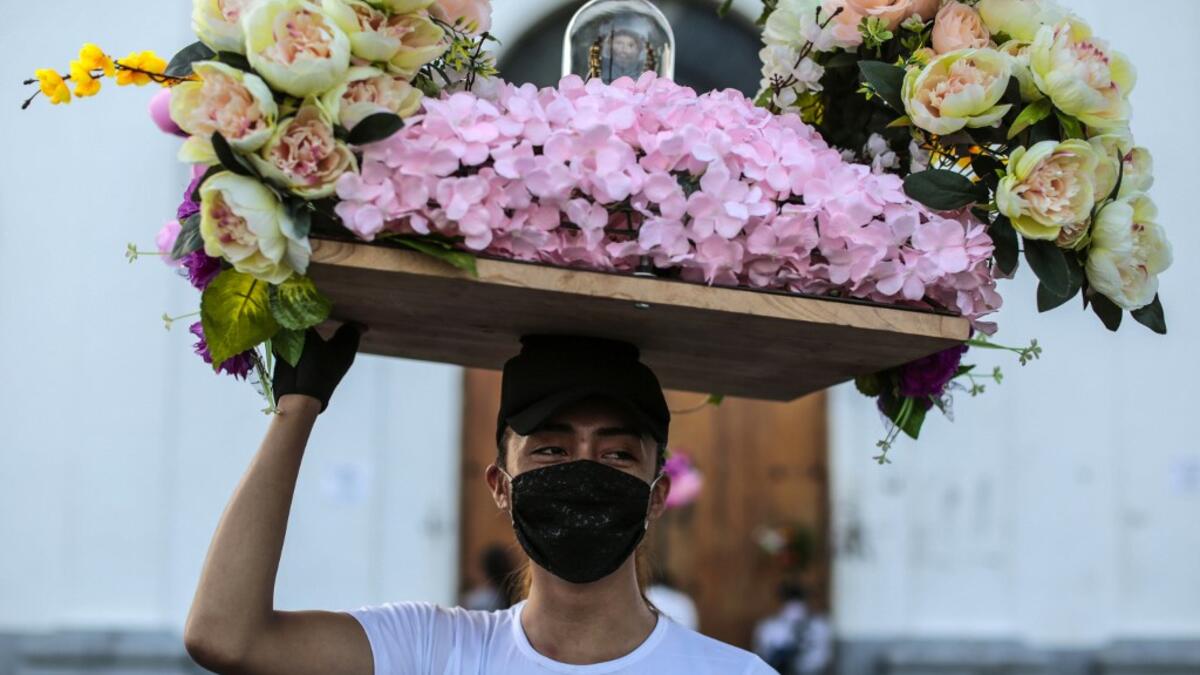 A Catholic faithful wears a face mask as a preventive measure against the spread of the novel coronavirus, COVID-19, during the opening of the ten-day celebration of the Santo Domingo de Guzman festival, outside the Las Sierritas de Santo Domingo church in Managua, on August 1, 2020. Despite the Catholic Church cancelling all religious activities due to the coronavirus pandemic, devotees gathered outside the church for the celebration. Inti OCON / AFP