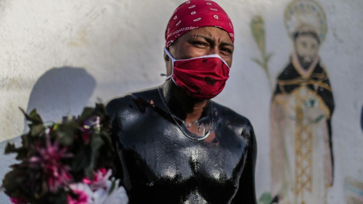 A Catholic faithful smeared in burnt oil poses for a picture as he takes part in the opening of the ten-day celebration of the Santo Domingo de Guzman festival, outside the Las Sierritas de Santo Domingo church in Managua, on August 1, 2020 amid the COVID-19 novel coronavirus pandemic. Despite the Catholic Church cancelling all religious activities due to the coronavirus pandemic, devotees gathered outside the church for the celebration. Inti OCON / AFP