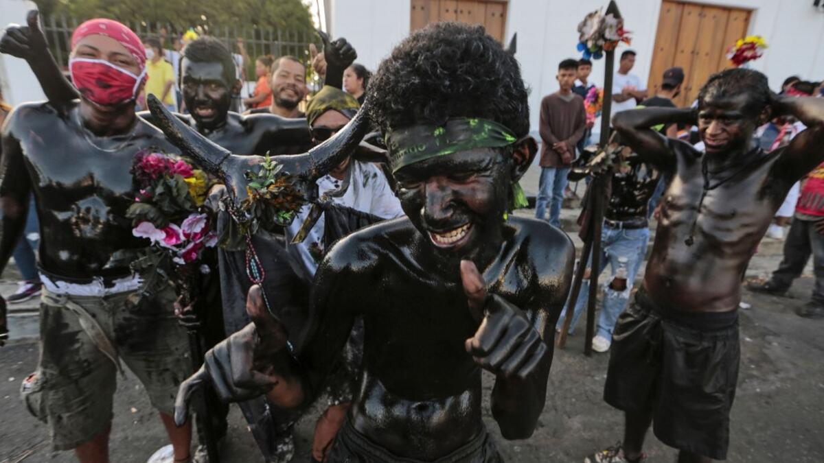 Catholic faithfuls smeared in burnt oil take part in the opening of the ten-day celebration of the Santo Domingo de Guzman festival, outside the Las Sierritas de Santo Domingo church in Managua, on August 1, 2020 amid the COVID-19 novel coronavirus pandemic. Despite the Catholic Church cancelling all religious activities due to the coronavirus pandemic, devotees gathered outside the church for the celebration. Inti OCON / AFP