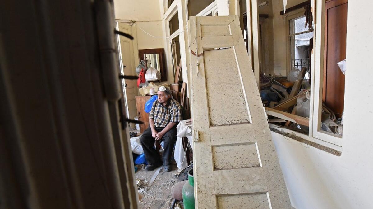 A man sits inside his damaged house in the Lebanese capital Beirut on August 6, 2020, two days after a massive explosion shook the Lebanese capital. The blast, which appeared to have been caused by a fire igniting 2,750 tonnes of ammonium nitrate left unsecured in a warehouse, was felt as far away as Cyprus, some 150 miles (240 kilometres) to the northwest. The scale of the destruction was such that the Lebanese capital resembled the scene of an earthquake, with thousands of people left homeless and thousan