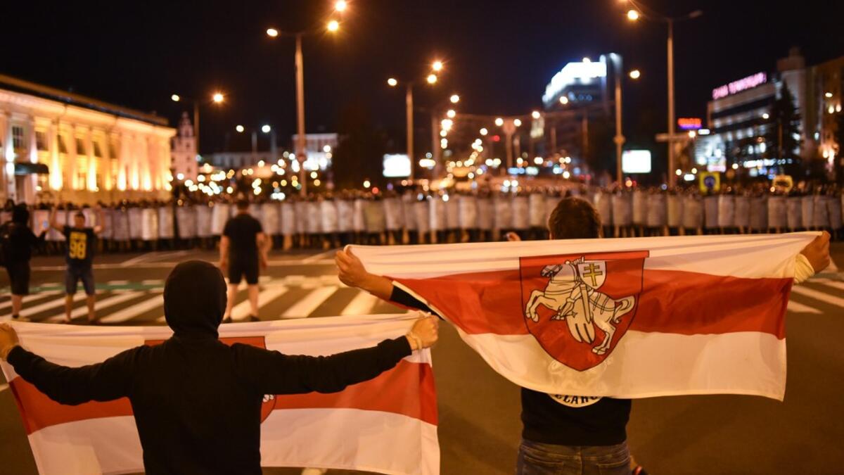 Demonstrators stand in front of riot police during a protest after polls closed in Belarus' presidential election, in Minsk on August 9, 2020. Sergei GAPON / AFP