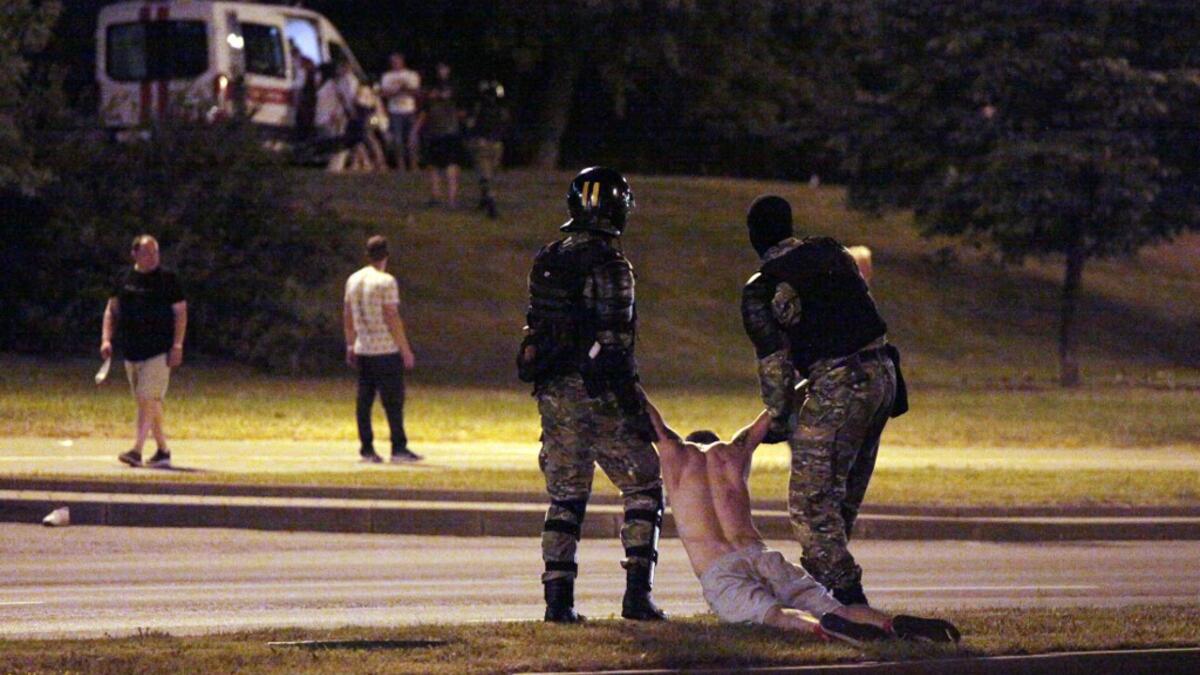 Riot police detain a protester after polls closed in the presidential election, in Minsk on August 9, 2020. Siarhei LESKIEC / AFP
