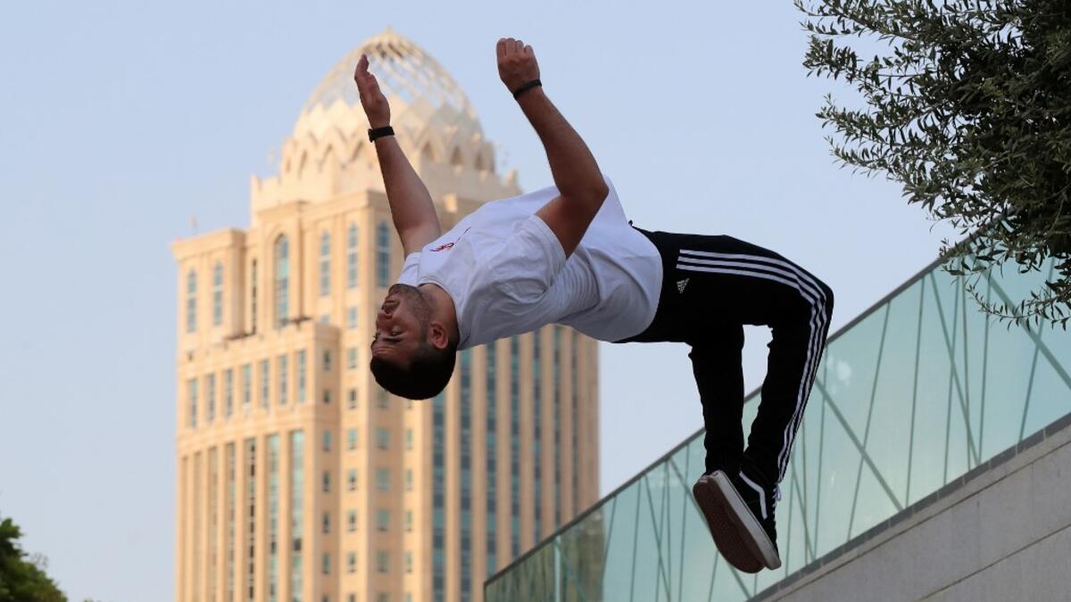 Achref Bejaoui, 25, performs parkour, a sport that originated in France in the 1990s, which involves getting around urban obstacles with a fast-paced mix of jumping, vaulting, running and rolling, in the Qatari capital Doha, on August 11, 2020. Parkour, also known as free-running, has now found a small but committed following in Qatar despite evening temperatures that hover around 40 degrees Celsius (104 Fahrenheit) in summer and over-zealous security guards unfamiliar with the sport. KARIM JAAFAR / AFP