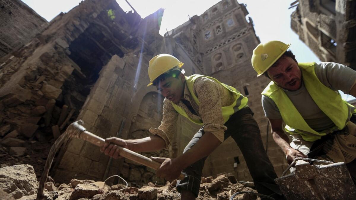 Yemeni labourers remove the rubble ahead of restoration works on the site of a collapsed UNESCO-listed building following heavy rains, in the old city of the Yemeni capital Sanaa, on August 12, 2020. Flash floods triggered by torrential rains have killed at least 172 people across Yemen over the past month, damaging homes and UNESCO-listed world heritage sites, officials said. Mohammed HUWAIS / AFP