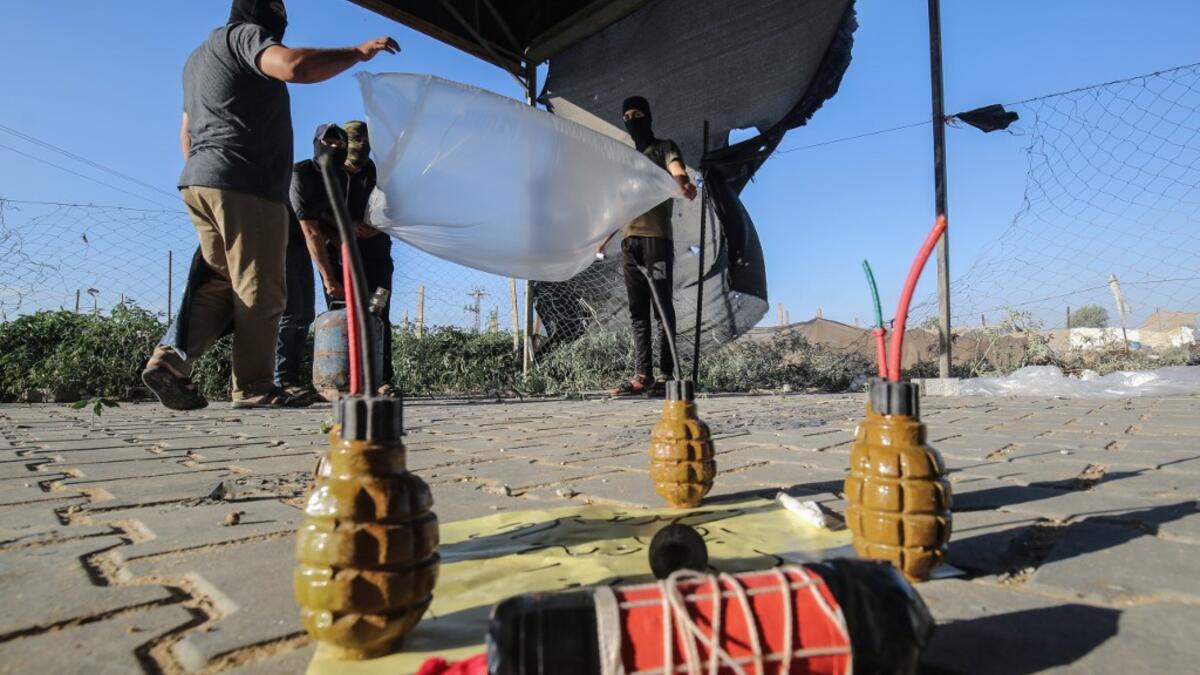 Palestinians inflate plastic bags before being attached with incendiary devices and flown towards Israel, near Rafah along the border between the Gaza Strip and Israel on August 21, 2020. SAID KHATIB / AFP