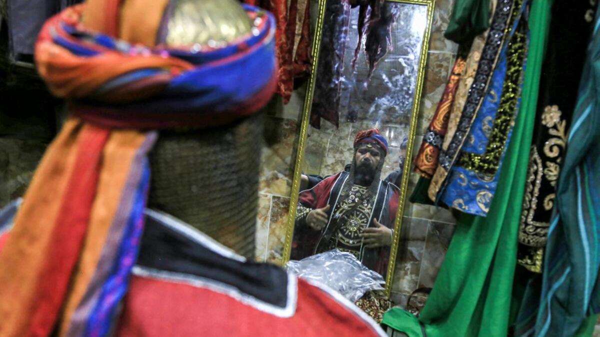 An Ashura re-enactor is assisted to get into costume before playing out a procession commemorating the entry of Imam Hussein and his family and retinue into Karbala, as Shiite Muslims mark the Ashura period in Iraq's central holy shrine city on August 22, 2020. Ashura is a period of mourning in remembrance of the seventh-century martyrdom of Prophet Mohammad's grandson Imam Hussein, who was killed in the battle of Karbala in modern-day Iraq, in 680 AD. Mohammed SAWAF / AFP