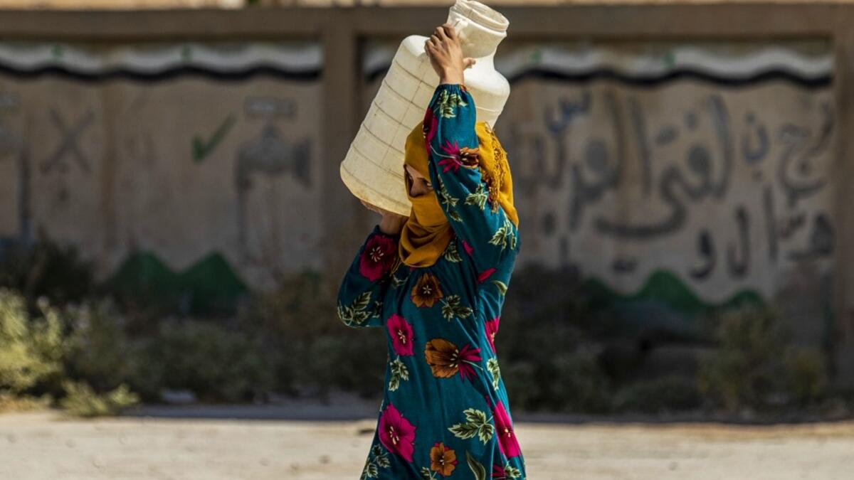 A displaced Syrian brings water back to their camp in a camp for the displaced in Syria's northeastern city of Hasakah on August 24, 2020. Delil SOULEIMAN / AFP