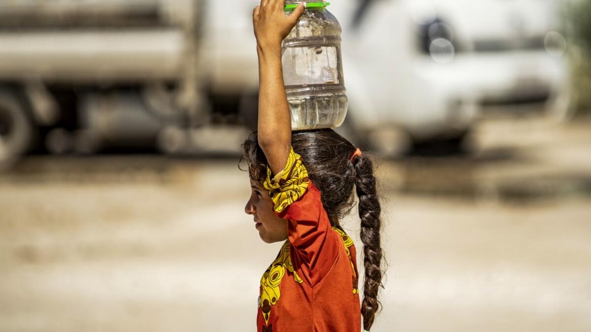 A displaced Syrian brings water back to their camp in a camp for the displaced in Syria's northeastern city of Hasakah on August 24, 2020. Delil SOULEIMAN / AFP