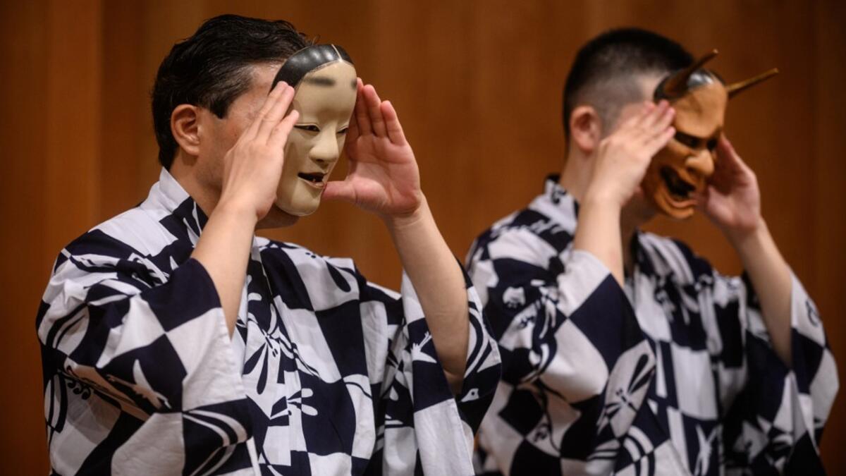 This photo taken on July 29, 2020 shows performer Kanta Nakamori (L) and his son Kennosuke Nakamori putting on masks as they take part in a rehearsal at the Kamakura Noh Theatre in the town of Kamakura in Kanagawa Prefecture, about one hour southwest of Tokyo. PHILIP FONG / AFP