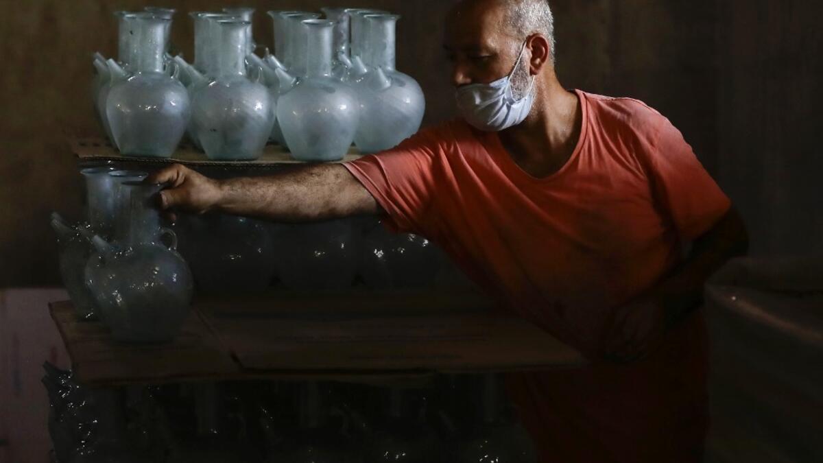 A worker arranges finished jugs at a factory, which is recycling the broken glass as a result of the Beirut explosion, in the northern Lebanese port city of Tripoli on August 25, 2020. The August 4 port explosion ripped through countless glass doors and windows when it laid waste to whole Beirut neighbourhoods, killing at least 190 people and wounding thousands more. Volunteers, non-governmental groups and entrepreneurs salvaged a fraction of the tonnes of broken glass that littered the streets, some of it