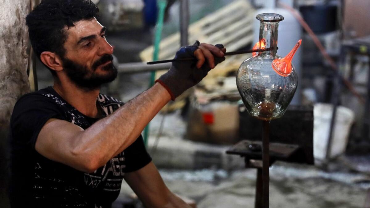A glassblower forms glass at factory, which is recycling the broken glass as a result of the Beirut explosion, in the northern Lebanese port city of Tripoli on August 25, 2020. The August 4 port explosion ripped through countless glass doors and windows when it laid waste to whole Beirut neighbourhoods, killing at least 190 people and wounding thousands more. Volunteers, non-governmental groups and entrepreneurs salvaged a fraction of the tonnes of broken glass that littered the streets, some of it through