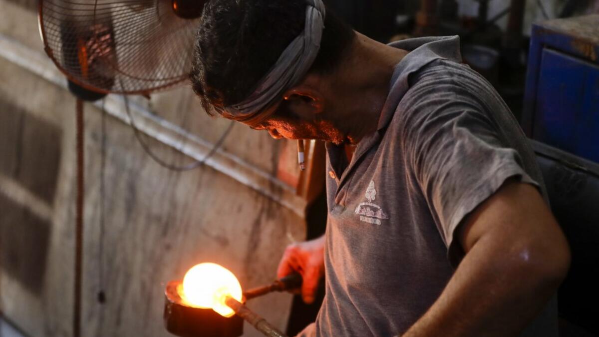 A glassblower forms glass at factory, which is recycling the broken glass as a result of the Beirut explosion, in the northern Lebanese port city of Tripoli on August 25, 2020. The August 4 port explosion ripped through countless glass doors and windows when it laid waste to whole Beirut neighbourhoods, killing at least 190 people and wounding thousands more. Volunteers, non-governmental groups and entrepreneurs salvaged a fraction of the tonnes of broken glass that littered the streets, some of it through