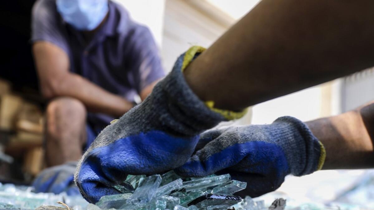 Workers sort through broken glass at factory, which is recycling the broken glass as a result of the Beirut explosion, in the northern Lebanese port city of Tripoli on August 25, 2020. The August 4 port explosion ripped through countless glass doors and windows when it laid waste to whole Beirut neighbourhoods, killing at least 190 people and wounding thousands more. Volunteers, non-governmental groups and entrepreneurs salvaged a fraction of the tonnes of broken glass that littered the streets, some of it