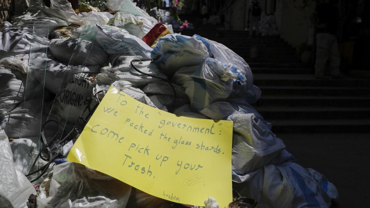 A picture taken on August 24, 2020, shows a note left by activists over a pile of collected glass in Beirut's Gemmayzeh neighbourhood. The August 4 port explosion ripped through countless glass doors and windows when it laid waste to whole Beirut neighbourhoods, killing at least 190 people and wounding thousands more. Volunteers, non-governmental groups and entrepreneurs salvaged a fraction of the tonnes of broken glass that littered the streets, some of it through recycling at Wissam Hammoud's family's gla