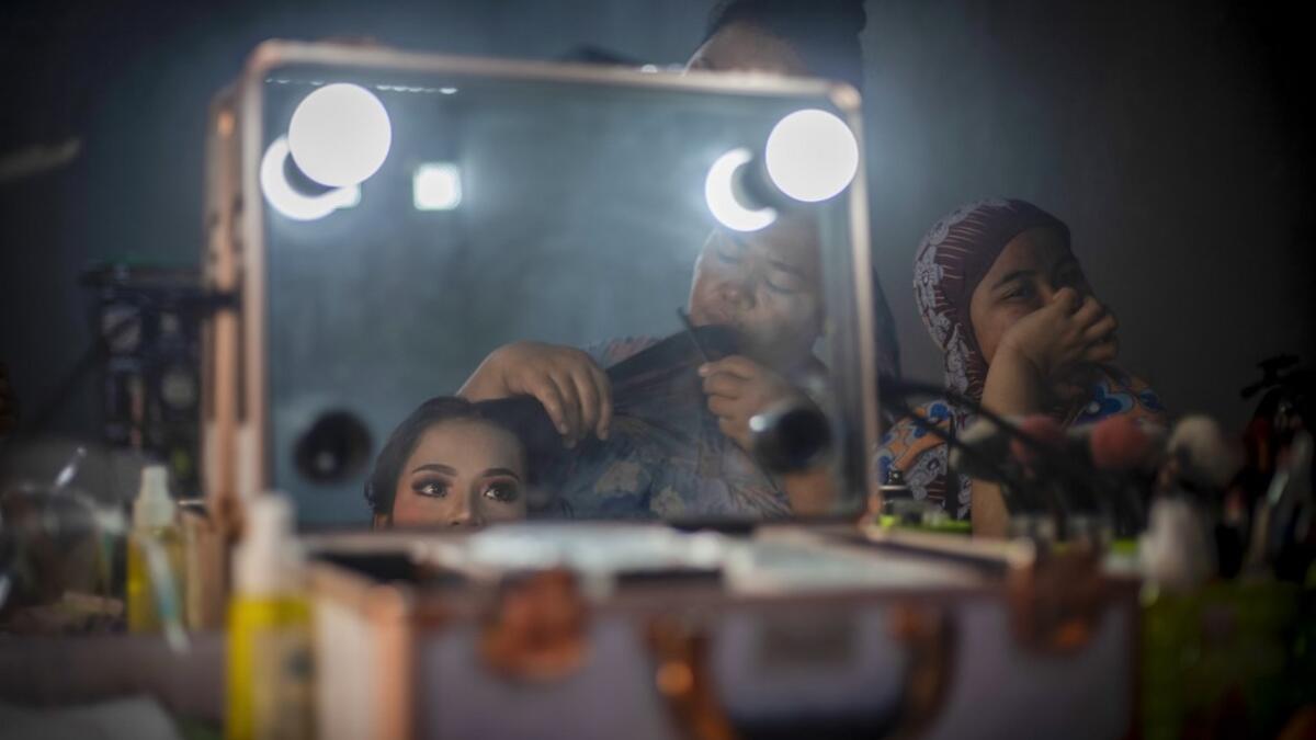 This picture taken on July 25, 2020 shows 18-year-old Lia (L, not her real name), wearing make-up and having her hair done, at her relative's house before getting married with 21-year-old Randi (not pictured) in the village of Tampapadang in Mamuju, West Sulawesi. Child marriage has long been common in traditional communities from the Indonesian archipelago to India, Pakistan and Vietnam, but numbers had been decreasing as charities made inroads by encouraging access to education and women's health services