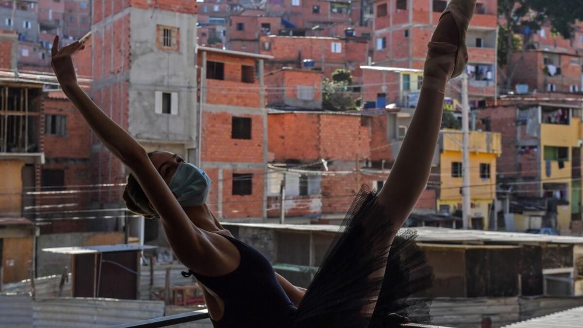Mariana Sousa, student of the Ballet Paraisopolis, warms up during a rehearse in Paraisopolis favela, outskirts of Sao Paulo, Brazil on August 27, 2020, amid the new coronavirus COVID-19 pandemic. NELSON ALMEIDA / AFP