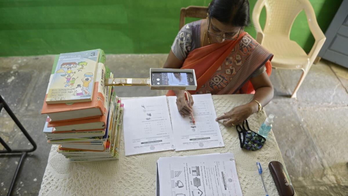 Headmistress M.C. Vijaya records worksheets on her mobile phone for the e-education classes at a government primary school in Nagireddypally Village of Siddipet District, some 50 kms from Hyderabad on September 1, 2020. AFP