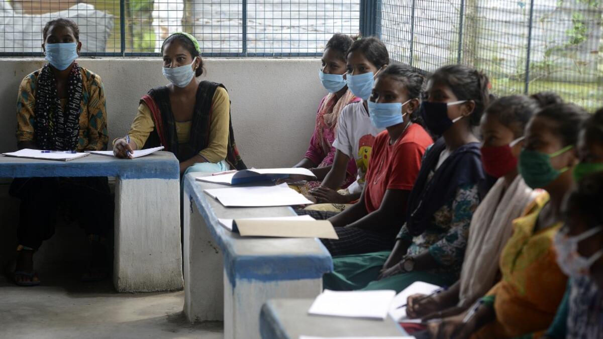 Youths from Merry view Tea Garden organisation attend a class as part of 'Tuition for Rs 10' project, origanized by Indian couple Anirban Nandy and Poulami Chaki Nandy for underprivileged students unable to assist online classes at Hatighisa village, some 26 km from Siliguri, on September 1, 2020, as schools remain closed due the Covid-19 coronavirus pandemic. DIPTENDU DUTTA / AFP