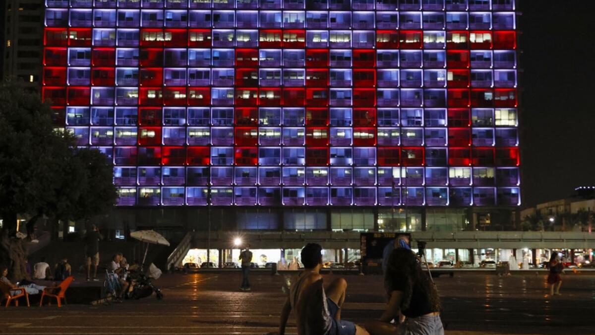 The windows of the Tel Aviv-Yafo Municipality building illuminated with the word "Peace" in English on September 15, 2020 to celebrate the signing of the landmark Israeli normalisation deals with the United Arab Emirates and Bahrain. Israeli Prime Minister Benjamin Netanyahu signed landmark accords normalizing the Jewish state's relations with the United Arab Emirates and Bahrain, as part of a peace push brokered by US President Donald Trump.  JACK GUEZ / AFP