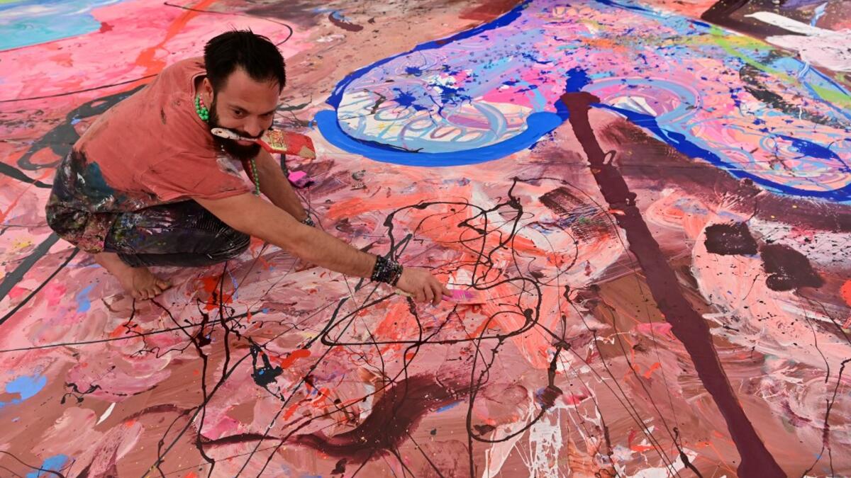 Contemporary British artist Sacha Jafri works on his record-breaking painting entitled 'The Journey of Humanity' on September 23, 2020, in the Emirati city of Dubai. The painting, which measures the size of two football fields, can be seen at a hotel in Dubai, where Jafri spent months of lockdown due to the coronavirus pandemic. The gigantic artwork is part of his project 'Humanity Inspired' and with it he hopes to raise 30 million USD to fund health and education initiatives for children living in poverty
