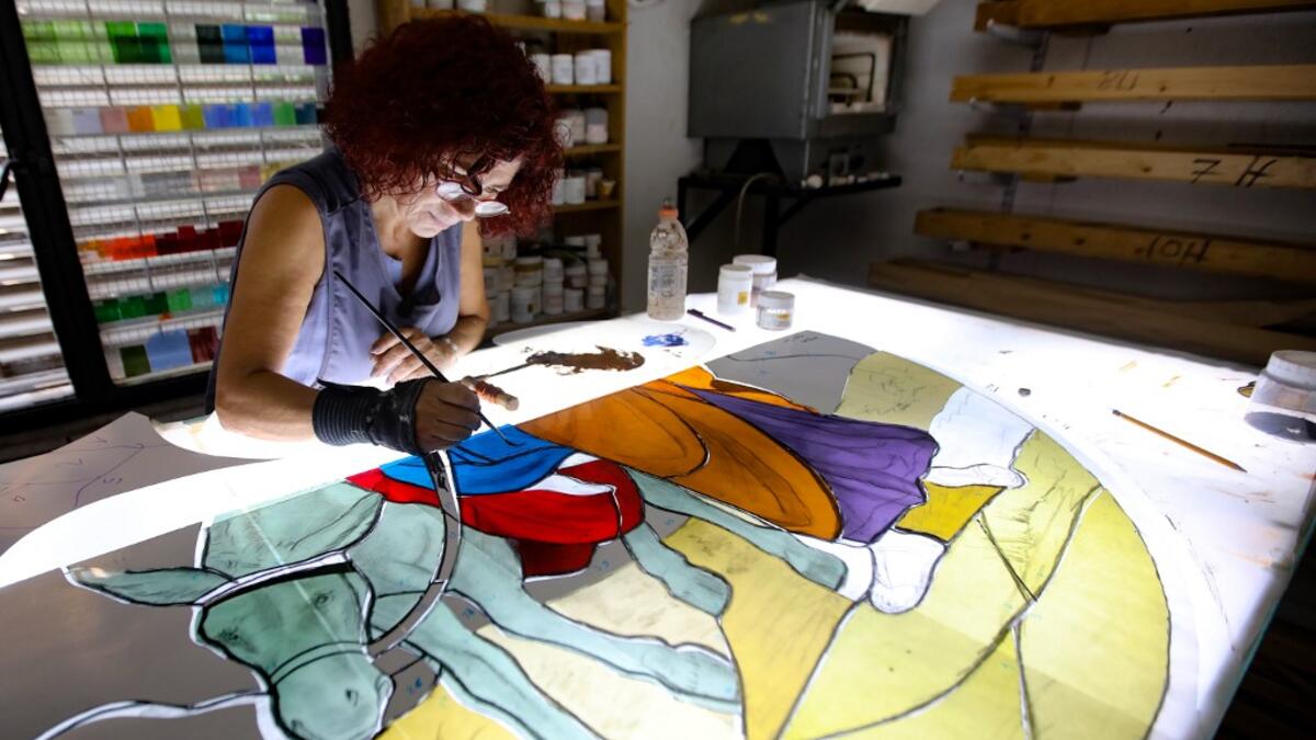 Lebanese stained glass artist Maya Husseini, 60, works on a piece for a cathedral under construction in Jordan, her main project before the Beirut port blast, in her basement workshop on the outskirts of the capital Beirut, on September 18, 2020. ANWAR AMRO / AFP