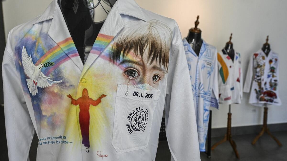 View of white coats used by doctors fighting against COVID-19 and decorated by Panamanian artists, in Panama City, on September 26, 2020. More than 20 doctor's coats fighting against COVID-19 that were disinfected and painted by Panamanian artists will be auctioned off from October 1 to 4. The funds will go to 20 health centers. Luis ACOSTA / AFP