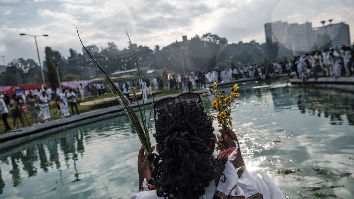 A woman sprays herself water as part of the celebration of “Irreechaa”, the Oromo people thanksgiving holiday, in Addis Ababa, Ethiopia, on October 3, 2020. Members of Ethiopia's largest ethnic group gathered under heavy security in Addis Ababa for a scaled-back version of their annual thanksgiving festival against a backdrop of unrest and political division. EDUARDO SOTERAS / AFP