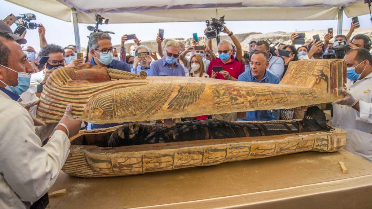 A picture taken on October 3, 2020 shows Egyptian Minister of Tourism and Antiquities Khaled Al-Anani (L), and Mustafa Waziri (R), Secretary General of the Supreme Council of Antiquities, open a sarcophagus excavated by the Egyptian archaeological mission working at the Saqqara necropolis, 30 kms south of the capital Cairo, which resulted in the discovery of a deep burial well with more than 59 human coffins closed for more than 2,500 years. They were unearthed south of Cairo in the sprawling burial ground