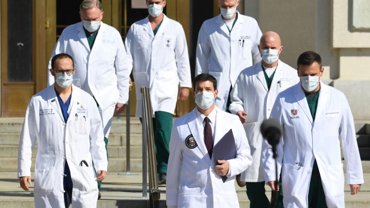 White House physician Sean Conley (C) arrives to answer questions surrounded by other doctors, during an update on the condition of US President Donald Trump, on October 5, 2020, at Walter Reed Medical Center in Bethesda, Maryland. President Donald Trump announced that he is leaving the hospital where he was given emergency treatment for Covid-19 and told the nation, where the virus has killed almost 210,000 people this year, that they have nothing to worry about. SAUL LOEB / AFP