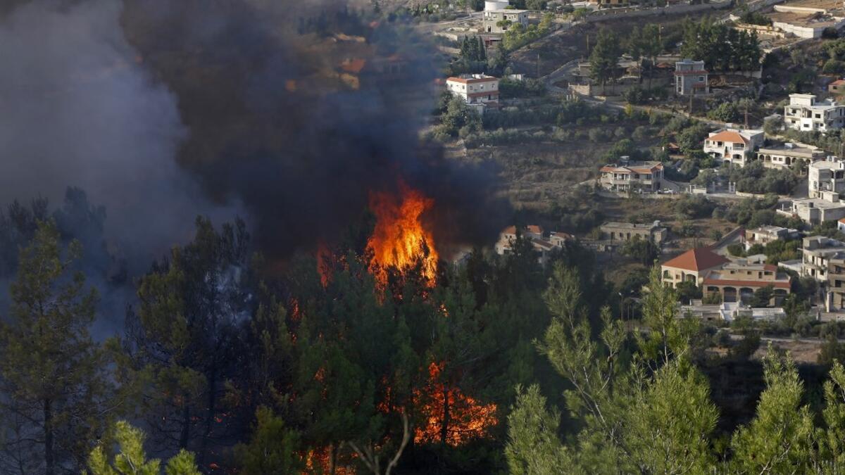 A picture taken near the northern Israeli kibbutz of Misgav Am in the Upper Galilee, shows a fire burning on the Lebanese side of the border with Israel on October 9, 2020. Several fires spread across northern and central Israel and the occupied West Bank as temperatures soared, forcing the evacuation of thousands of people, authorities said.  JALAA MAREY / AFP