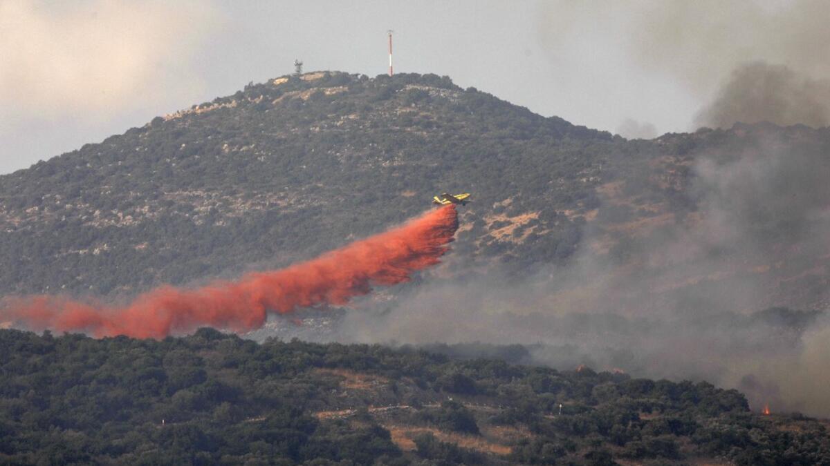 A firefighting plane tries to extinguish a forest fire near the Israeli military base of Har Dov on Jabal al-Shaykh, a strategic and fortified outpost at the crossroads between Israel, Lebanon, and Syria, on October 10, 2020. JALAA MAREY / AFP