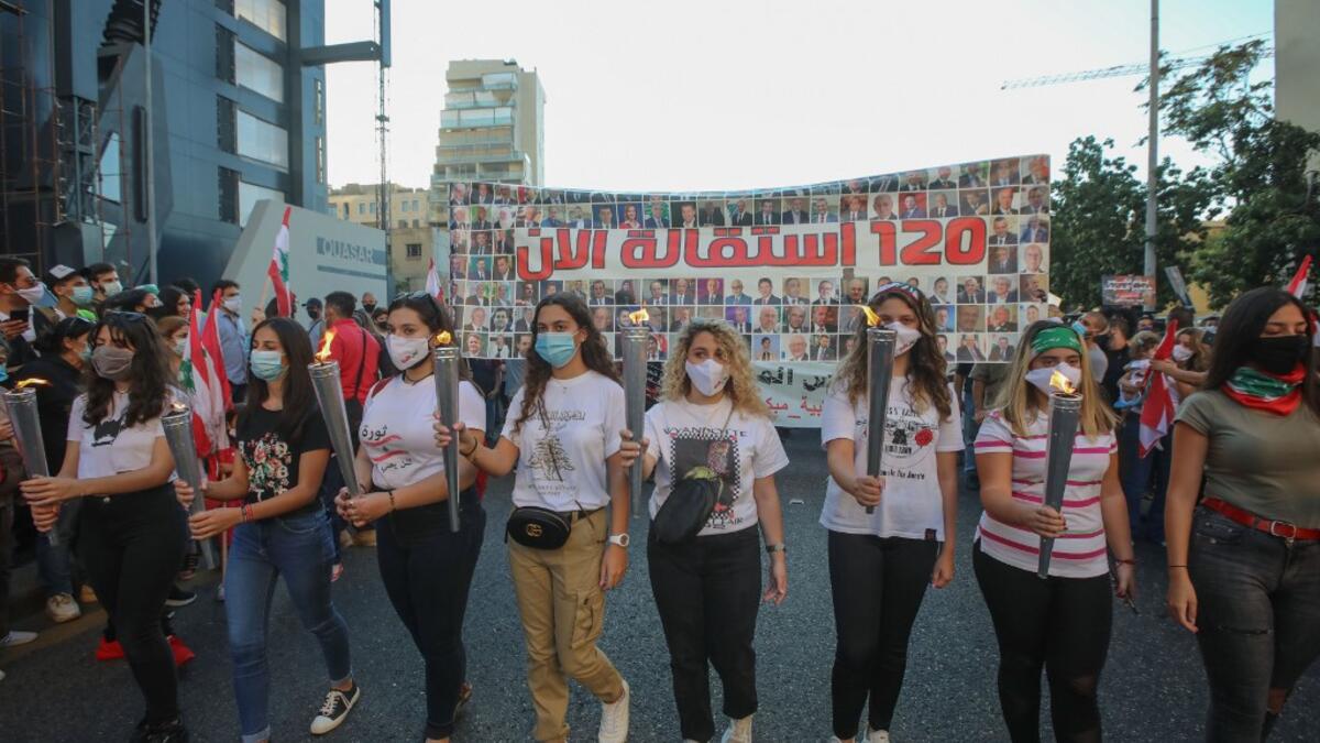 Lebanese protesters carry torches during a demonstration marking the one year anniversary of the beginning of a nationwide anti-government protest movement, in the capital Beirut on October 17, 2020. ANWAR AMRO / AFP