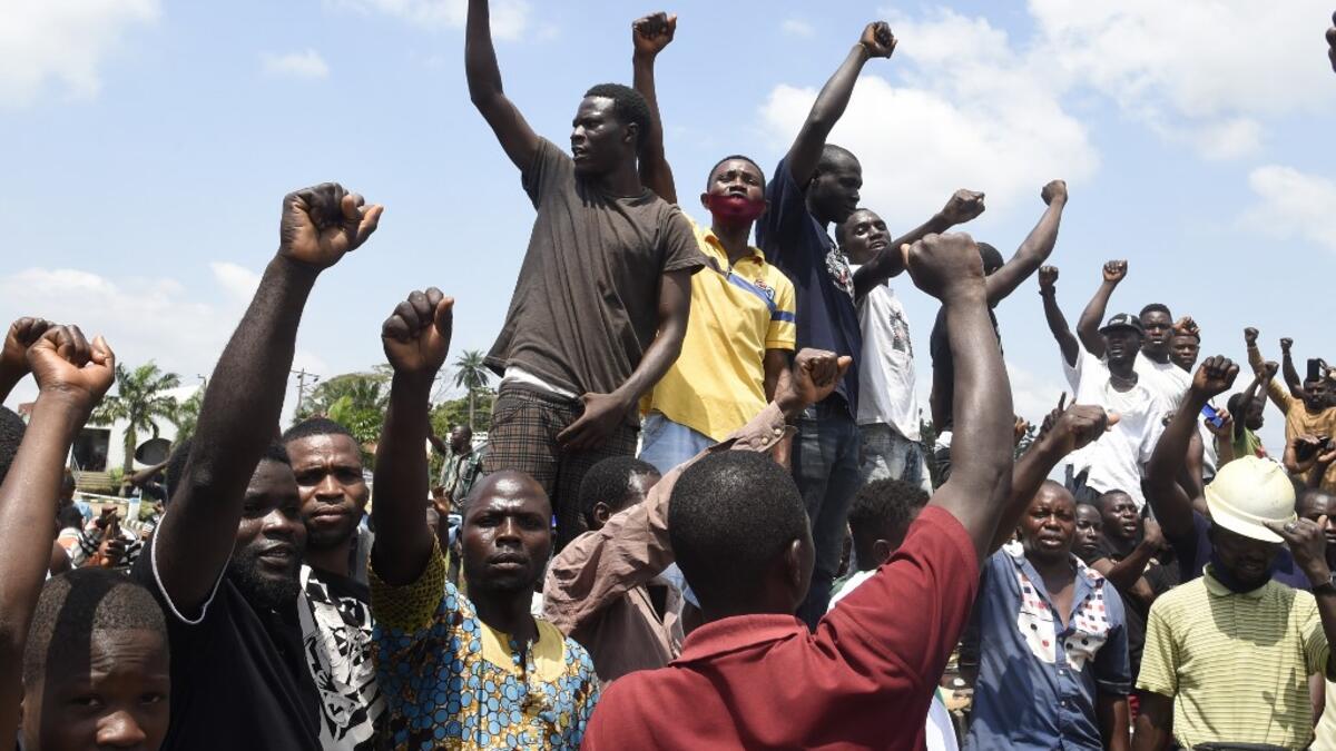Protesters chant and sing solidarity songs as they barricade barricade the Lagos-Ibadan expressway to protest against police brutality and the killing of protesters by the military, at Magboro, Ogun State, on October 21, 2020. Buildings in Nigeria's main city of Lagos were torched on October 21, 2020 and sporadic clashes erupted after the shooting of peaceful protesters in which Amnesty International said security forces had killed several people. Witnesses said gunmen opened fire on a crowd of over 1,000 p