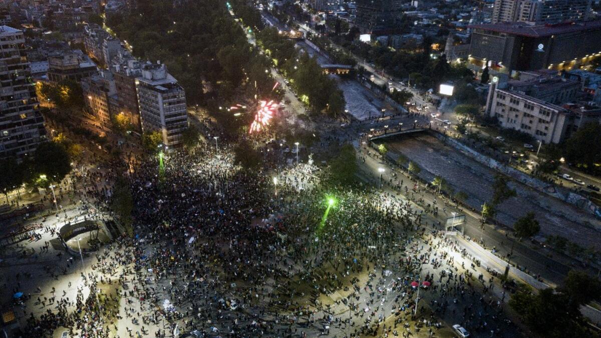 Aerial view of Plaza Italia square showing people gathering as they wait for the official result on the constitutional referendum voting, in Santiago on October 25, 2020. A year to the day after more than one million people thronged downtown Santiago in the biggest Chile's social uprising, Chileans vote Sunday on whether to change the country's dictatorship-era constitution seen as underpinning the nation's glaring inequalities. JAVIER TORRES / AFP