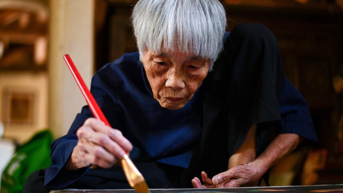 This photograph taken on October 8, 2020 shows 89-year-old Vietnamese artist Mong Bich painting at her house in Bac Ninh province, east of Hanoi. Bich specialises in silk paintings of daily life and ordinary people, women in particular, and ploughed a lonely furrow during many years of war when artists were steered towards the army or frontline workers as subjects. Manan VATSYAYANA / AFP