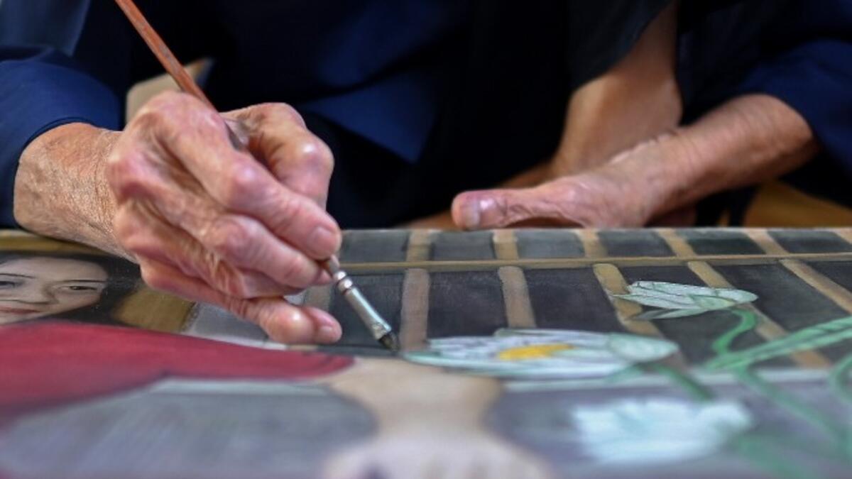 This photograph taken on October 8, 2020 shows 89-year-old Vietnamese artist Mong Bich painting at her house in Bac Ninh province, east of Hanoi. Bich specialises in silk paintings of daily life and ordinary people, women in particular, and ploughed a lonely furrow during many years of war when artists were steered towards the army or frontline workers as subjects. Manan VATSYAYANA / AFP