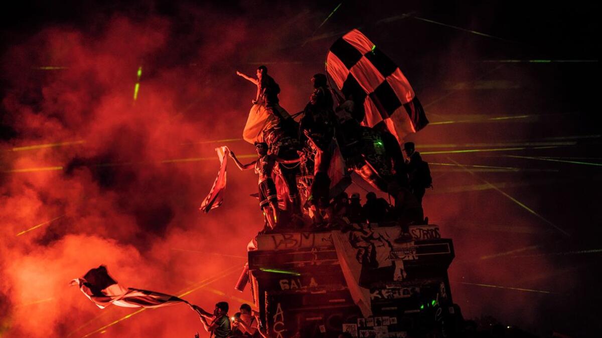 Demonstrators climb a statue in Plaza Baquedano on the night of 30 November 2019. Protesters, often together with football supporters, frequently gathered on Plaza Baquedano over weekends to chant and celebrate.⁣ ⁣ From ‘Chile: The Rebellion Against Neoliberalism’ by Fabio Bucciarelli (@fabio_bucciarelli) for L’Espresso (@espressosettimanale).⁣ (Instagram)