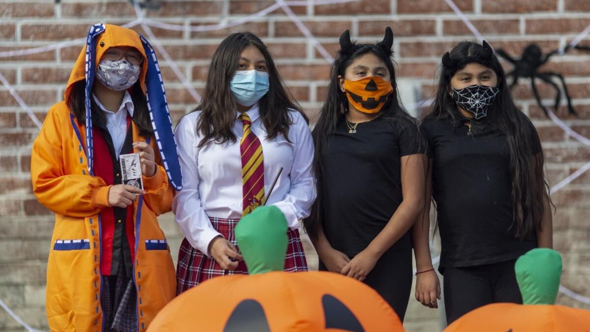 People pose for a photo booth picture at the "Halloween Driving Howl" event in Alhambra, California, on October 31, 2020. The city of Alhambra is holding several social distancing Halloween events as the Covid-19 pandemic continues to worsen across much of the nation. DAVID MCNEW / AFP