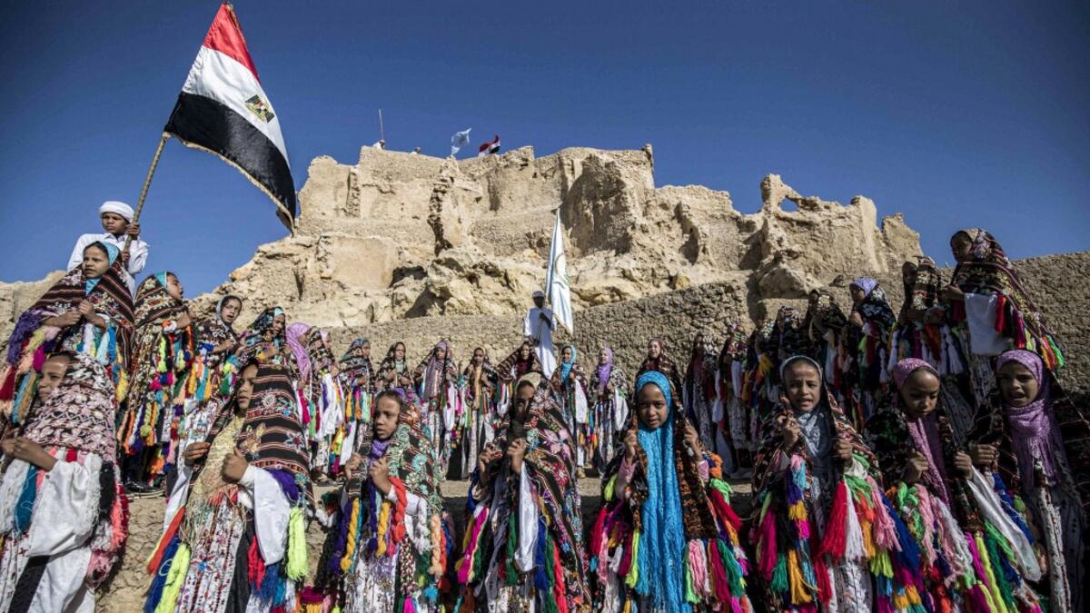 Egyptian school children dressed in traditional outfits, gather during a celebration to mark the inauguration of the fortress of Shali following its restoration, in the Egyptian desert oasis of Siwa, some 600 kms southwest of the capital Cairo, on November 6, 2020. Khaled DESOUKI / AFP