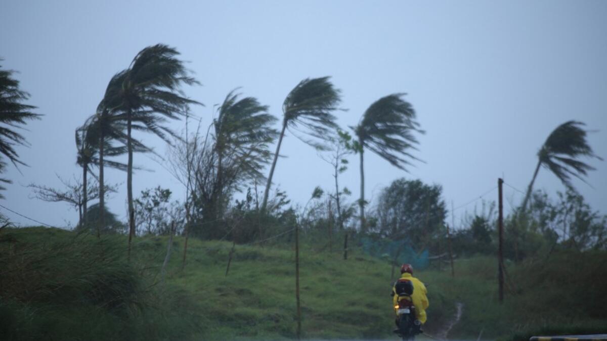 A motorist passes along a street amidst strong winds in Legazpi City, Albay province on November 11, 2020, ahead of the landfall of Tropical Storm Vamco -- expected to intensify into a typhoon -- in the region devastated by two typhoons in less than three weeks. Charism SAYAT / AFP