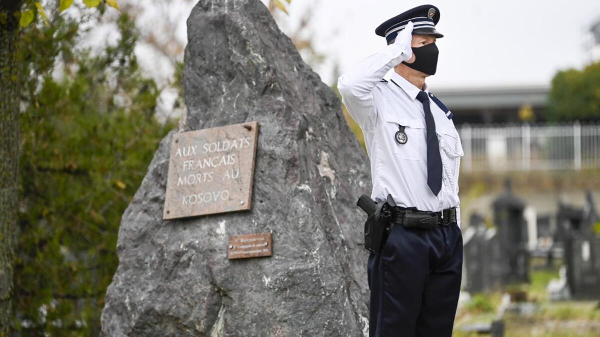 A member of the French national police stands to attention as he take part in a ceremony for the French soldiers of the Front d'Orient (1915-1918) who died in Kosovo, at the Military square in Pristina on November 11, 2020, during the Armistice Day commemorations marking the 102nd anniversary of the end of WWI (World War One). Armend NIMANI / AFP